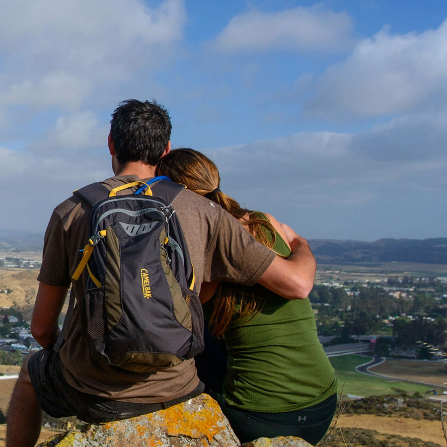 Two people looking out over a hill while hiking