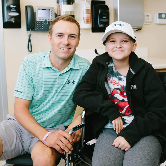 a man and his son smiling at the camera from a hospital room