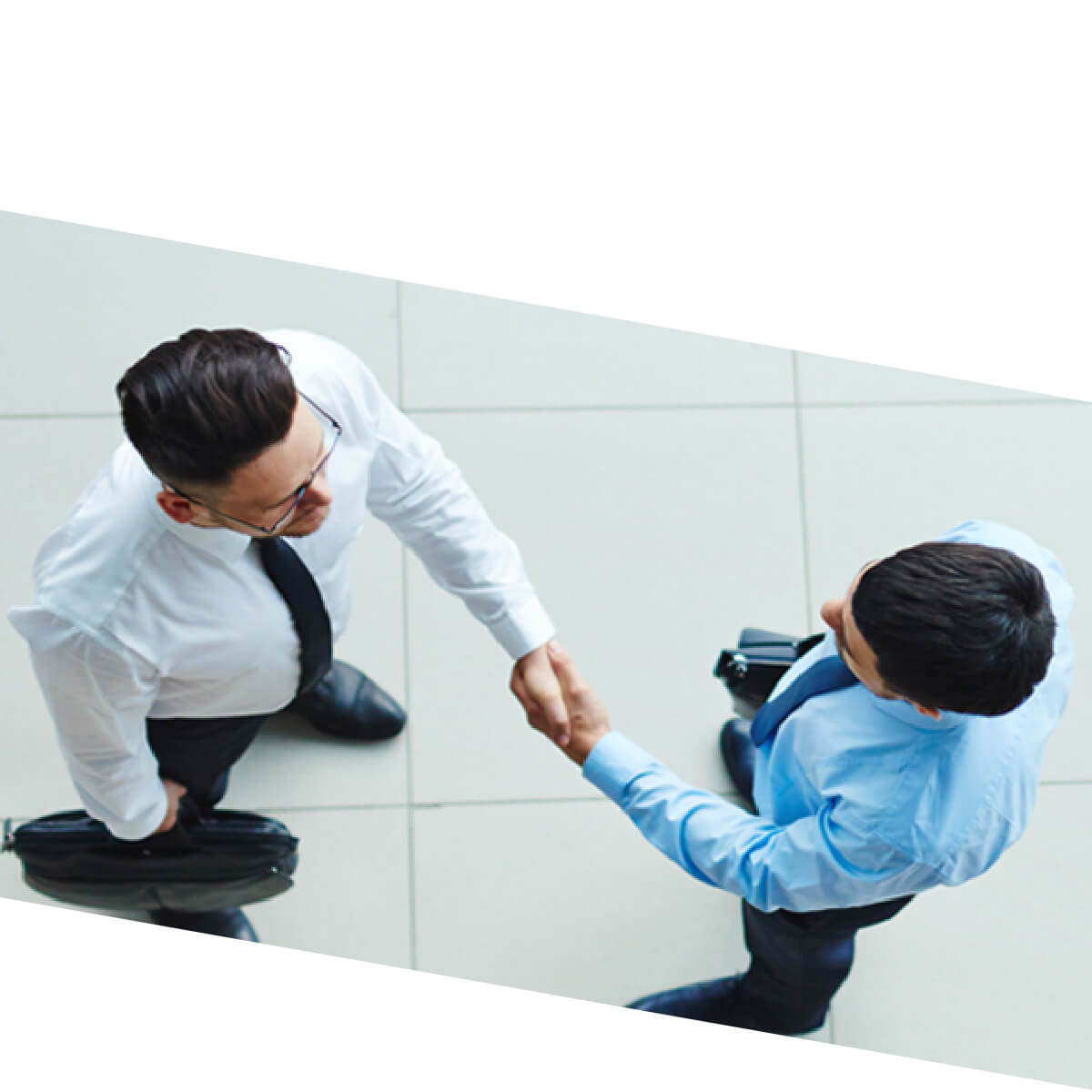 two businessmen in suits shaking hands from the top down