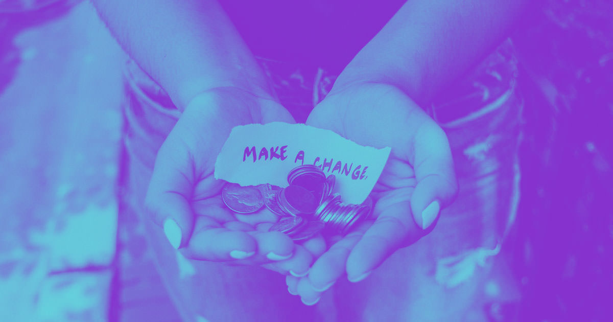 cupped hands holding a pile of coins and a paper reading "make a change" 